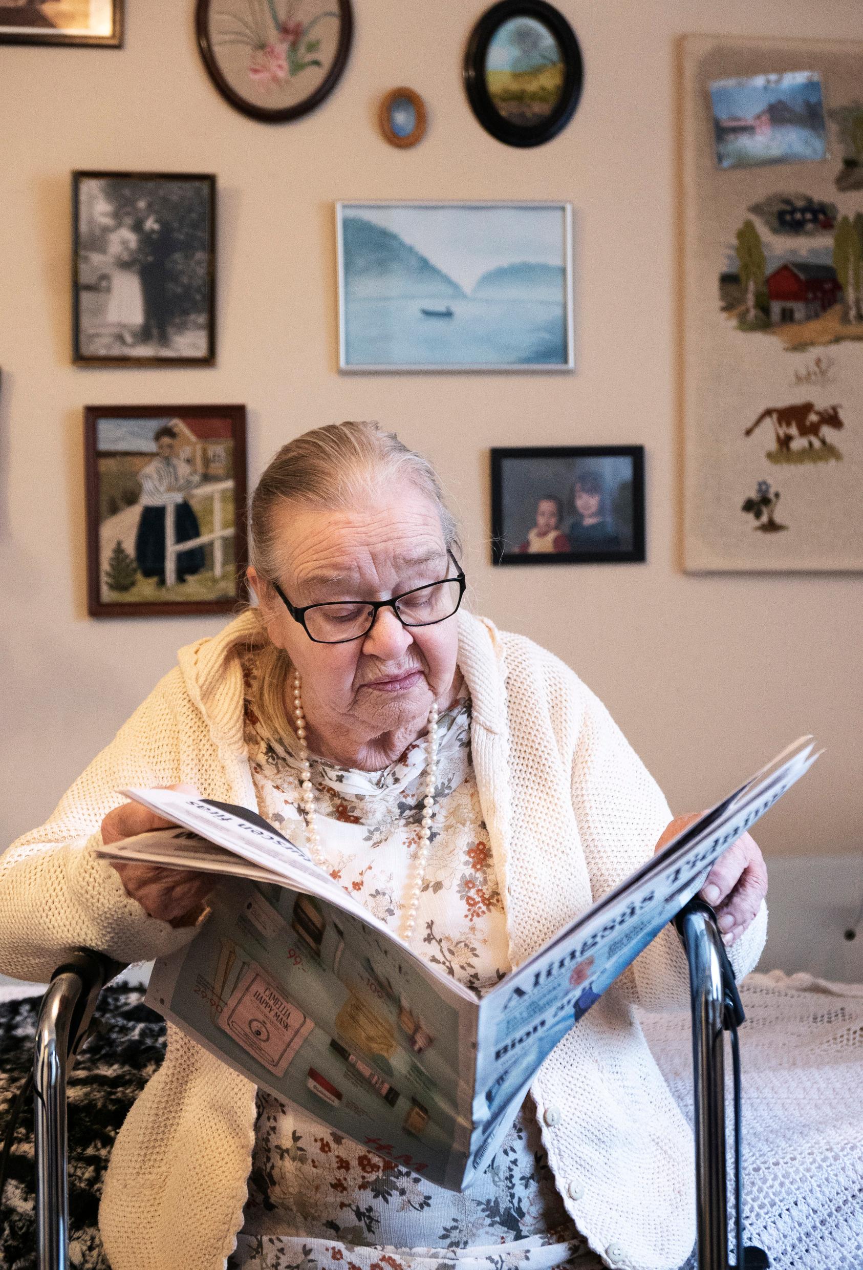 Пожилая женщина читает газету